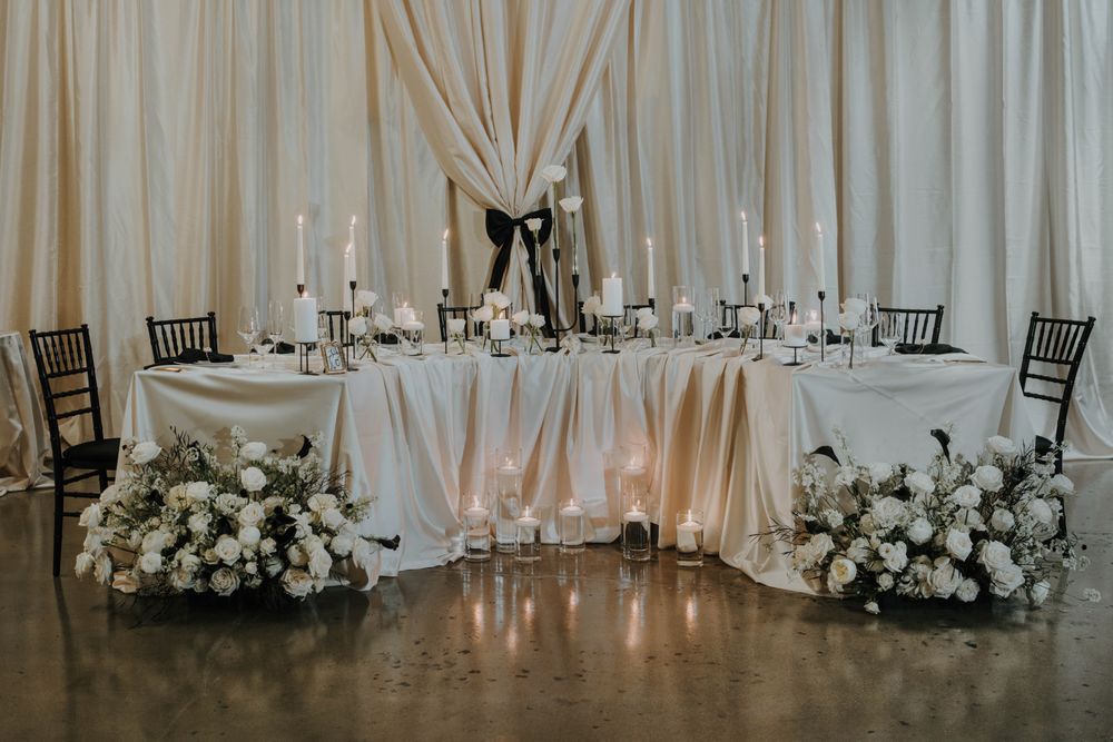 Elegant sweetheart table with chiavari chair rentals fabric draping and candlelight decor for Mountain View wedding reception