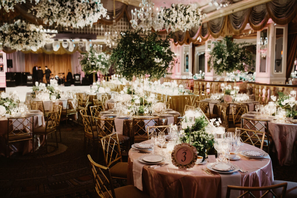 Luxury indoor wedding reception with elegant table and chair rentals floral chandeliers and linen decor in Campbell California