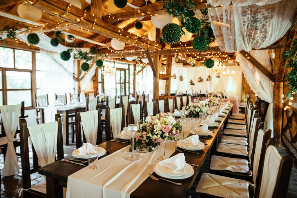 Rustic barn wedding reception with long table and chair rentals string lights and floral decorations in Sunnyvale California