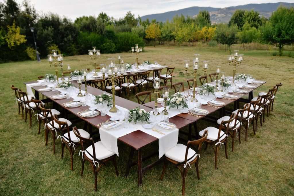 Elegant outdoor wedding reception with rectangular table setup and wooden chairs rental in Los Altos Hills California